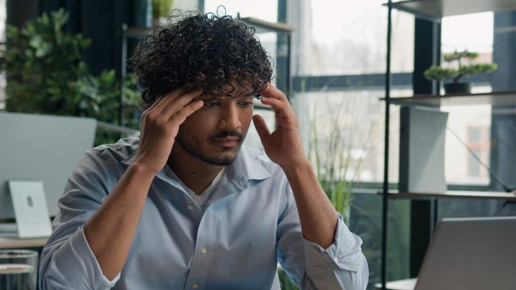 Homme fatigué au travail illustrant les effets du burn out, apaisé par le CBD BUDDY BOO.