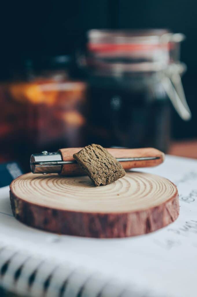 Résine CBD Buddy Boo présentée sur un support en bois, parfaite pour fumer ou vaporiser.