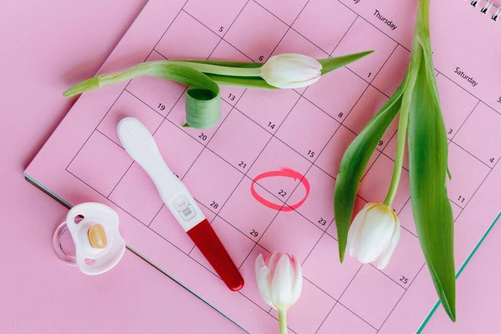 Test de grossesse posé sur un calendrier, symbolisant l’impact possible du cannabis sur la fertilité et le cycle féminin – BUDDY BOO.