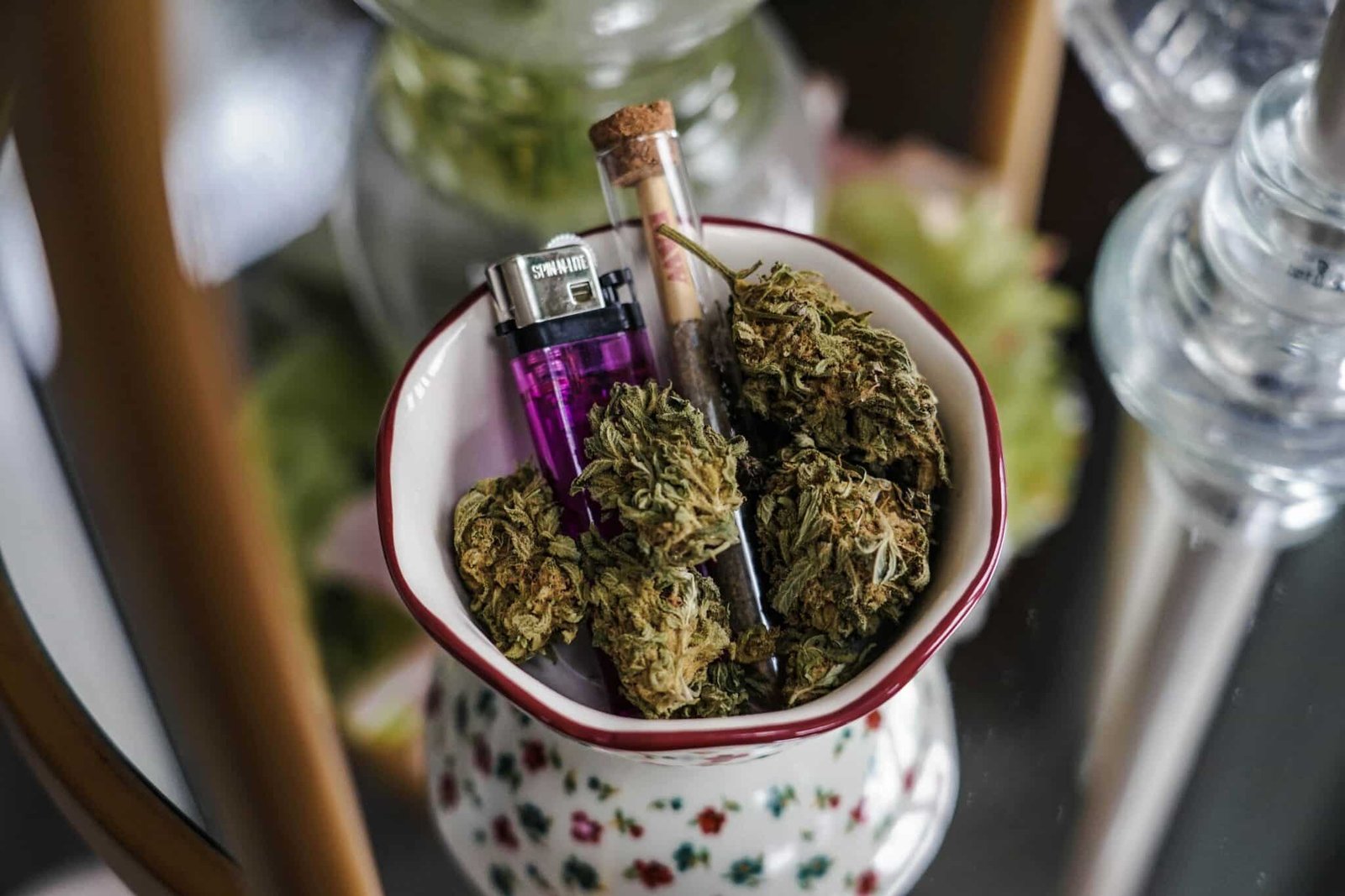 Fleurs de cannabis dans un bol avec un briquet et un joint pour illustrer l’effet entourage selon BUDDY BOO.
